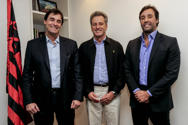 Gabriel Pentagna Guimarães (diretor presidente do BS2), à esquerda, e Rodrigo Pentagna Guimarães (vice-presidente comercial do BS2), à direita do presidente Rodolfo Landim - Foto: Marcelo Cortes / Flamengo